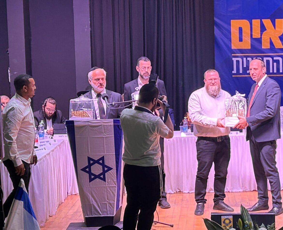 רה"ע שמואל גרינברג בחלוקת שי לחברי המועצה היוצאים, במהלך ישיבת מועצת העיר הראשונה. צילום: חדשות העיר